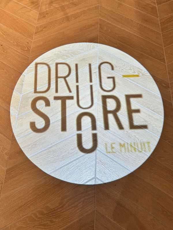 Logo du Drugstore Le Minuit projeté sur le sol du magasin